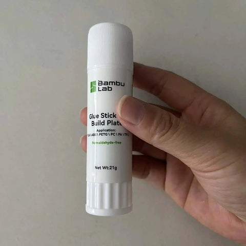Hand holding a hot bed glue stick for 3D printing, suitable for A1 Mini P1 X1 printers with strong bed adhesion and easy release.