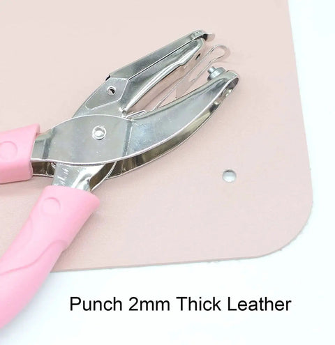 Mini One Quarter Inch Circle Hole Punch With Pink Soft Grip punching 2mm thick leather, shown in use, durable metal build.