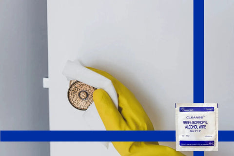 Using 99.9 Percent Isopropyl Alcohol Wipes For Electronics And Screens 50 Count 6x5in to clean a doorknob with a glove.