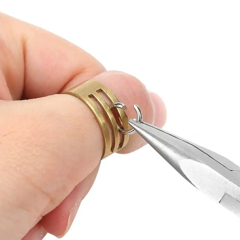 Hand using pliers from 7 Piece Jewelry Pliers Set For Beading And Wire Wrapping on brass rings for jewelry making.
