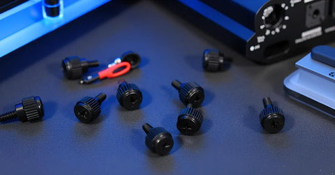 Close-up of 24 Pack Computer Case Thumb Screws 6-32 Thread M3.5x6 Knurled Black Fasteners on a desk