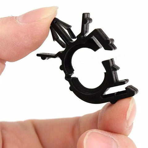 Hand holding a black clip from 60 Piece All In One Car Wire Loom Harness Routing Clips Kit 6 Size Assortment Releasable Push Mount Tie Wraps And Wiring Retainers Durable Nylon Universal Clips For Vehicle Boat Trailer UTV And More.