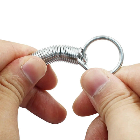 Close-up of hands holding a silver galvanized metal spring from the 20 Pack Spring Latch Hooks for Pet Cages and Doors Metal Finger Locks.