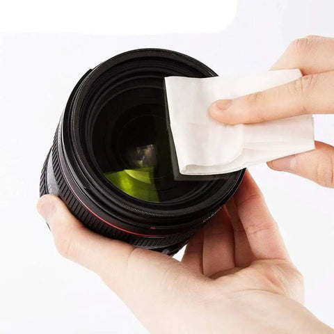 Cleaning a camera lens with Lint Free Lens Cleaning Tissues 4x3 Inches for Microscope Lenses 250 Sheets, close-up view.
