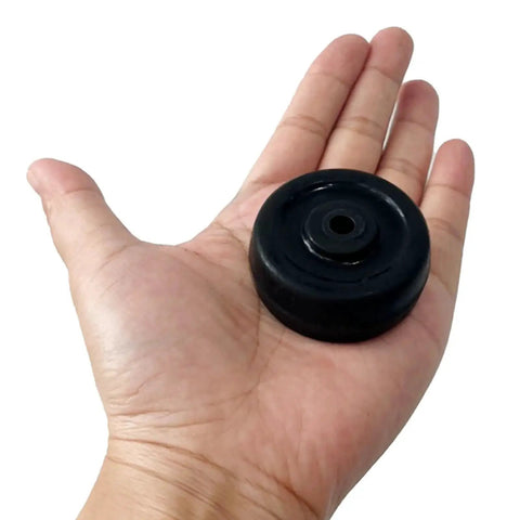 Hand holding a single 2 Inch Diameter Rubber Caster Wheel 50x25mm Bore 6.5mm Black for trolleys and carts.