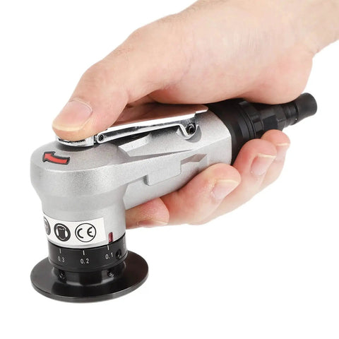 Hand holding silver pneumatic air grinder for precise cutting and shaping in woodworking projects