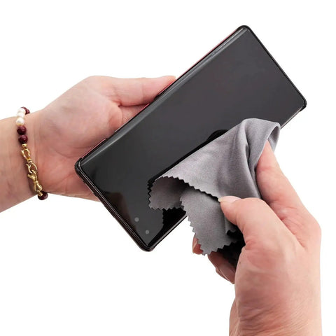 Person cleaning smartphone screen with 30 Pack Microfiber Cleaning Cloths For Glasses Lenses And Screens 6x7in