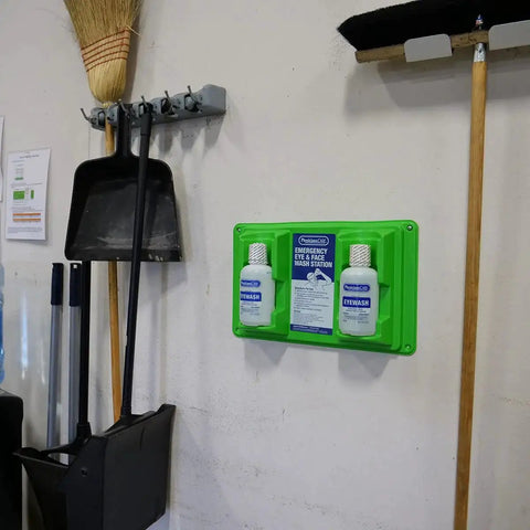 Wall Mount Eyewash Station With Dual 32 Ounce Sterile Isotonic Buffered Eye Wash Bottles installed on a wall next to tools.