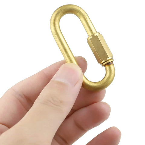 Hand holding Brass Quick Links D Shape Screw Locking M4 5/32 Inch, showing corrosion-resistant connector for outdoor use.