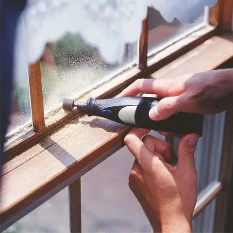 Person using Aluminum Oxide Sanding Drum Set Kit With Free Box 132 Piece Pack Including 120 Sanding Sleeves In 3 Diameters And 12 Shank Drums For Dremel Rotary Tools DIY Friendly For Wood Metal Fiberglass Finishing on window frame