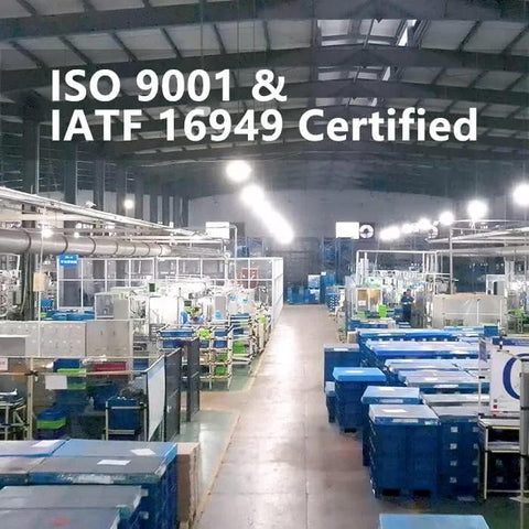 Interior of an ISO 9001 and IATF 16949 certified manufacturing facility with machinery and storage containers.