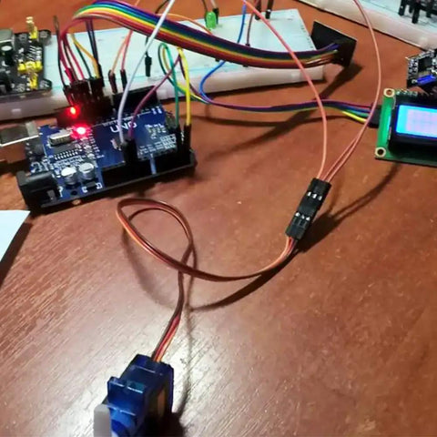 Four Pack 9G Micro Servo Motors SG90 180 Degree Control For Arduino Raspberry Pi in electronics setup on wooden table
