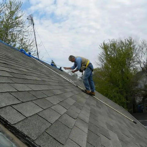 Worker using Heavy-Duty Roof Safety Anchor For First Man Up And Last Man Down, 5,000-Lb Capacity on steep-slope asphalt roof.