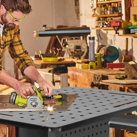 Man using power tool on 36 By 24 Inch Welding Table With Wheels Mobile Steel Workstation Heavy Duty Design for sawing and fabrication