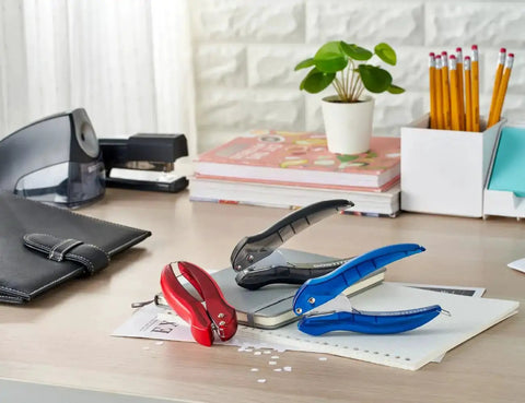 EZ Squeeze Hole Punch For Crafting And School Projects 3 Pack with single hole punch displayed in black, red, and blue on a desk.