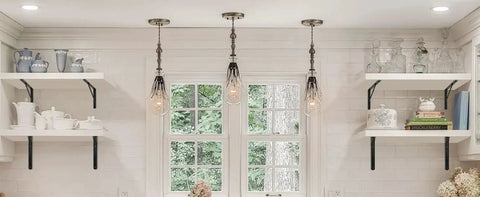 Kitchen with black L-shaped brackets supporting white shelves, displaying dishes and decor items, under pendant lights.