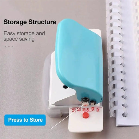 6 Hole Punch Handheld Metal Craft Tool For Binding Notebooks And Scrapbooks, resting next to spiral notebook, easy portable design
