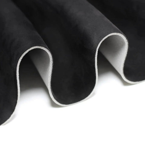 Close-up of black suede headliner fabric with foam backing for car truck SUV roof interiors, showing material texture and layers.
