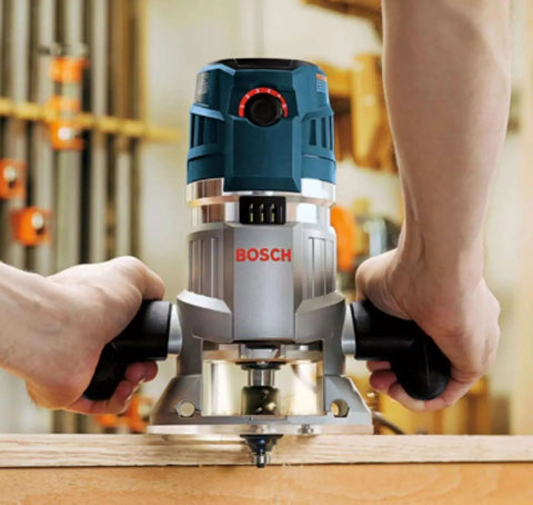 Hands using Bosch router with 15 Piece Micrograin Carbide Tipped Wood Router Bit Set Universally Compatible For DIYers.