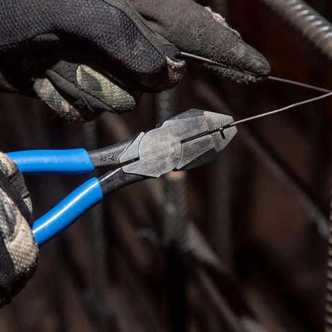 Heavy Duty Slim Head Diagonal Cutters With Spring Loaded Action For Cutting ACSR Nails Screws And Soft Rebar Tie Wire Induction Hardened Blades For Longevity Forged In USA Ironworker Pliers From Klein Tools held by gloved hand cutting wire in construction setting