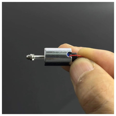 Close-up of a Mini Round 10mm Solenoid Electromagnet with 7.4V 9V 12V DC, suction push pull type, held between fingers, 5.5mm plunger stroke.