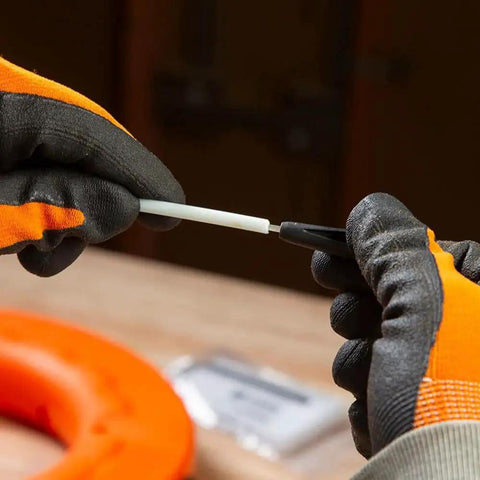 Close-up of Non Conductive Fish Tape Repair Kit for Fiberglass Tapes Made In USA in use showing assembly of an eyelet with gloves.