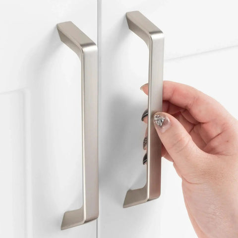 Hand holding 10 Pack 5 Inch Hole Centers Brushed Nickel Cabinet Pulls, zinc alloy hardware, installed on white cabinet