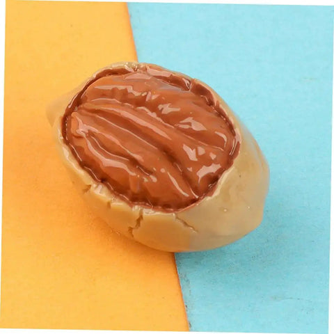 Close-up of a realistic resin walnut from the Twenty Piece Miniature Resin Nut Embellishments For Dollhouse Food Props on colorful backdrop.