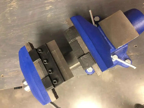 4 Inch Vise Mount Press Brake Bender Attachment for Sheet Metal Cross Slide, shown clamped in a blue vise, top view.