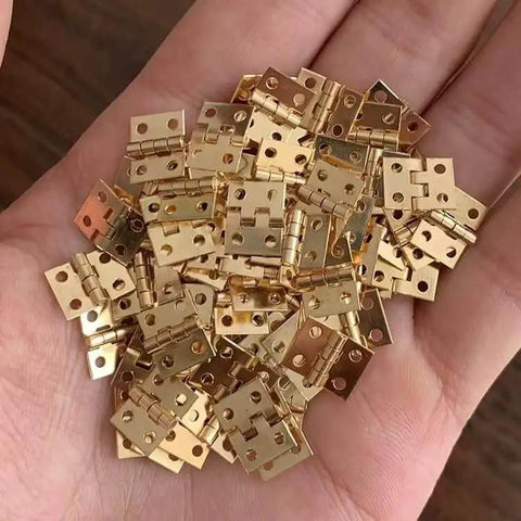 Hand holding 1 Set 1/12 Scale Tiny Dollhouse Door Hinges With 4 Pieces And 16 Screws For Totally Realistic Dollhouse Furniture
