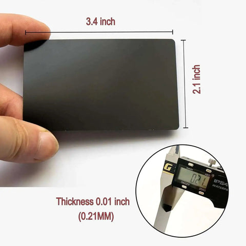 Person holding Fifty Pcs Matte Black Metal Business Card Blanks For Laser Engraving, showing size 86 x 54 mm, 0.21 mm thickness.