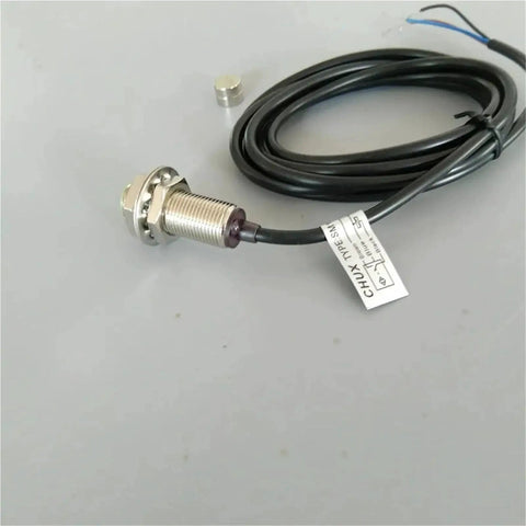 Front view of Amazon M12 magnetic switch sensor with threaded metal housing, mounting nut, and black cable