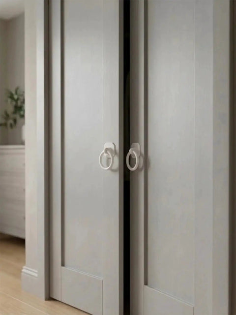 Large White Ring Bi-Fold Closet Door Pulls With Protective Base 1-3/5 Inch installed on wooden sliding doors in a modern setting.