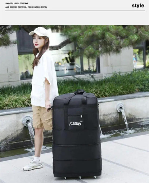 Woman standing with Expandable Extra Large Travel Duffel Bag With Six Wheel Spinner, Waterproof Oxford Fabric, in outdoor setting.