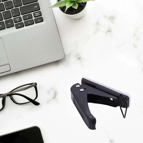 Black Go-To One Quarter Inch Single Hole Puncher With 20-Sheet Capacity on office desk near laptop and glasses.