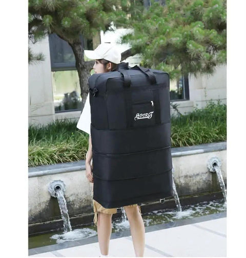 Person carrying Expandable Extra Large Travel Duffel Bag With Six Wheel Spinner, Waterproof Oxford Fabric, Lightweight Rolling Suitcase