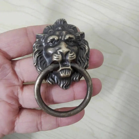 Antique Bronze Lion Head Ring Pull Cabinet Handles Set Of 4 With Screws, 2.6 Inches Long By 1.6 Inches Wide, shown in hand
