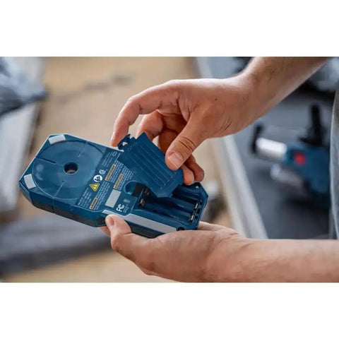 Hands opening battery compartment of Pro Grade Wall Scanner For Electricians And Contractors All In One Multi Function Stud Finder And Live Wire Detector Locates Wood Studs Metal Framing Copper Pipes And Live Electrical Wires Behind Drywall.