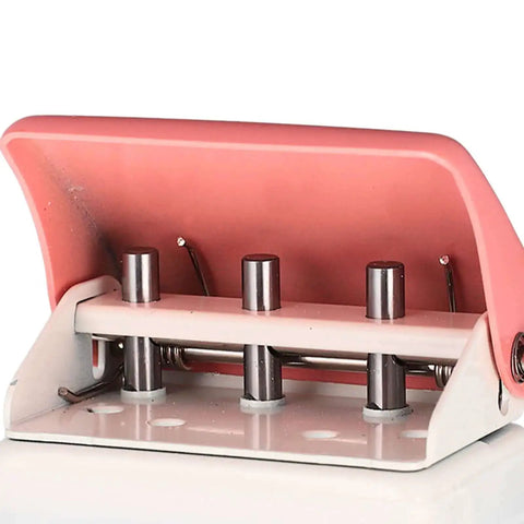 Close-up of pink three hole punch handheld paper puncher with five sheet capacity and alignment posts for quick accurate punching.