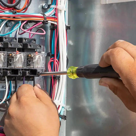 27 In 1 Precision Screwdriver Set With Onboard Storage And Rare Earth Magnet, 26 Precision Bits Plus A 3.5 Mm Nut Driver in use on terminal block