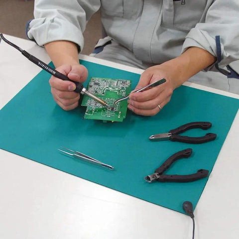 Person using Pro Grade ESD Soldering Mat Roll for Electronics Repair Ultra Large 23.7 by 118 Inch Rubber Anti Static Desk Pad.