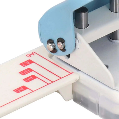 Close-up of 3 Hole Paper Puncher Handheld DIY Tool for B5 Papers showing plastic cover, metal body, and adjustable paper guide