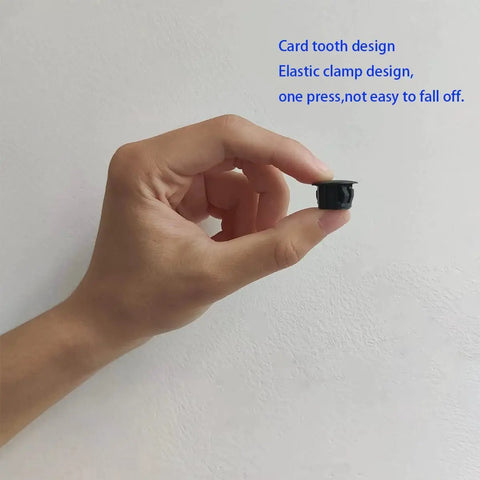 Hand holding Thirty Pcs Black Plastic Hole Plugs For Cabinet And Screw Holes, 13 Mm Bottom Diameter, 17 Mm Cap Diameter
