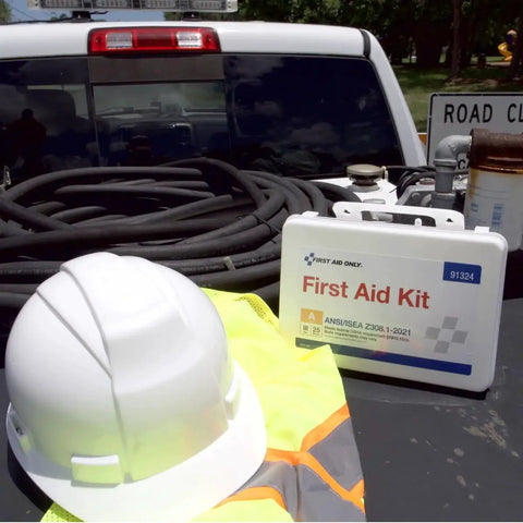 ANSI 2021 A OSHA Compliant 94 Piece 25 Person First Aid Kit on truck bed with hard hat and safety vest