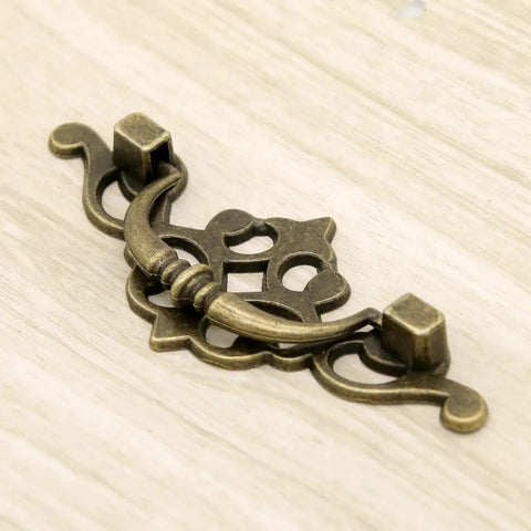 Vintage Antique Brass Bail Pull Handles Set For Wooden Drawers Cabinets And Cupboards Four Pack With Distressed Zinc Alloy Finish And Anti Rust Durability Includes 3.8 Inch Length 1.6 Inch Height Center To Center 2.6 Inch Spacing For Retro Decor close-up view."}