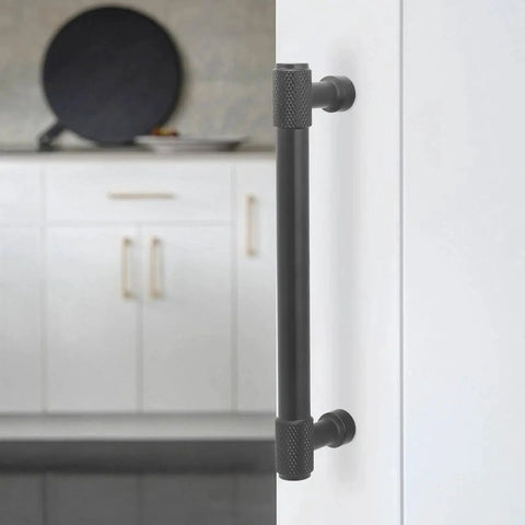 Installed 5-inch matte black knurled cabinet handle shown on white kitchen cabinet