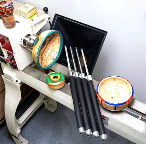 Carbide Turning Tools Set For Acrylic Resin And Hybrid Wood Lathe Work With 12 Inch Tools And 17 Inch Handles Four Piece USA Made Lathe Tool Kit displayed on a lathe with turned wood and resin bowls
