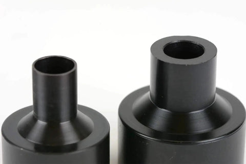 Close-up of two black metal dimple dies from the Dimple Die Set Tool Kit Pro Grade Eight Dies One Half Inch Three Quarter Inch One Inch One And A Quarter Inch One And A Half Inch One And A Three Quarter Inch Two Inch Two And A Half Inch For Auto Sheet Metal Fabrication And Automotive Parts.