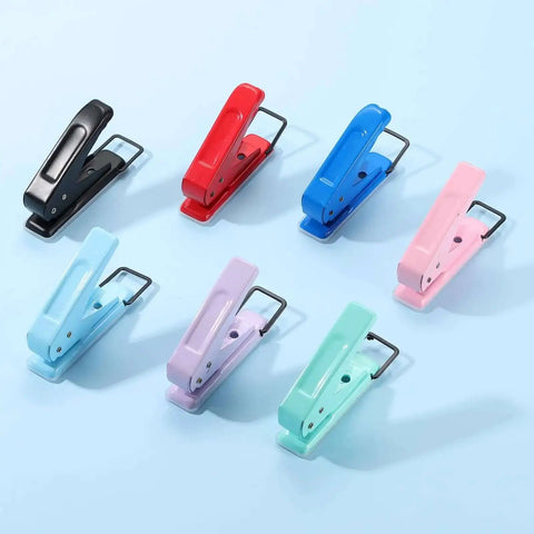 Colorful handheld paper punches on a blue background, featuring various shades including black, suitable for tags, crafts, and scrapbooks.