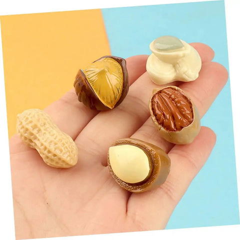 Hand holding Twenty Piece Miniature Resin Nut Embellishments For Dollhouse Food Props Realistic Walnuts And Nuts For DIY Crafts